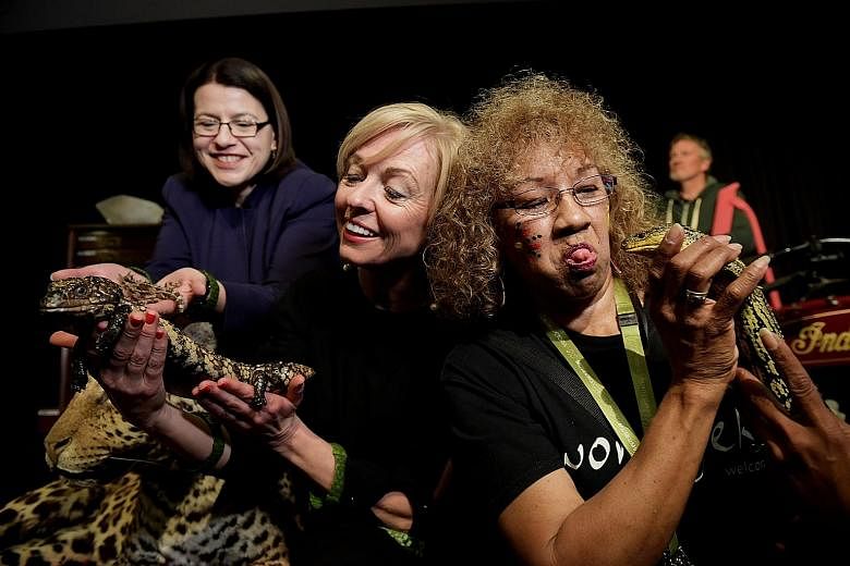 From left: Australia's Minister for Families and Children Jenny Mikakos, Museums Victoria CEO Lynley Marshall and tour guide Victoria Barnett getting up close with lizards at the launch of the "Museum Inside Out" exhibition at Melbourne Museum, Victo