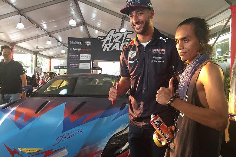 Red Bull driver Daniel Ricciardo with Singapore urban artist Zul Othman, also known as Zero, after signing off on a hand-painted Aston Martin DB11 he had helped to put the finishing touches on at the Marina Barrage Art of Racing event. The Australian