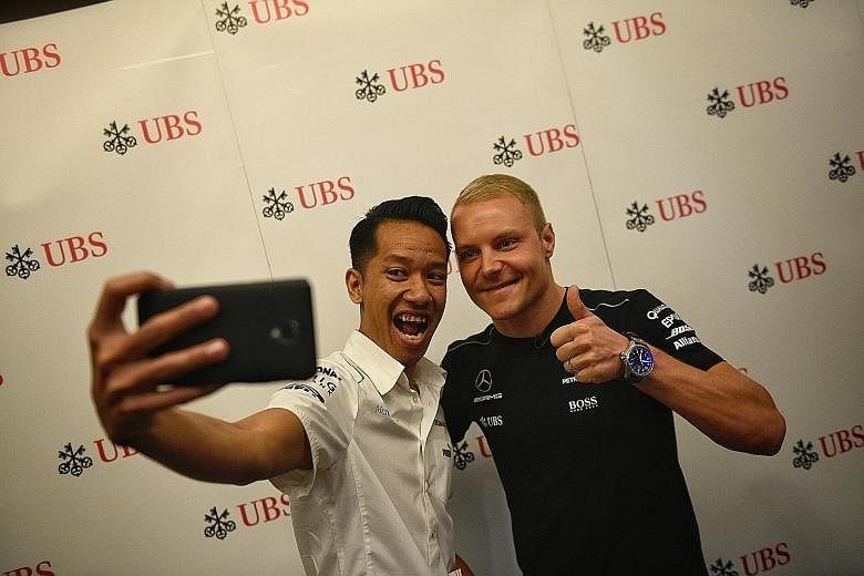 ST reader Ruslan Rusli Lim posing for a wefie with Mercedes driver Valtteri Bottas at a UBS event. While the Finn trails team-mate Lewis Hamilton and Ferrari's Sebastian Vettel by a large margin, he will not give up.