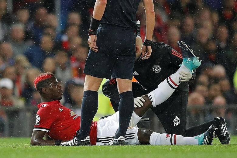 Manchester United's Paul Pogba receiving medical attention for an injury suffered during the 3-0 Champions League victory against Basel at Old Trafford on Tuesday. It was the Frenchman's first game as United captain.
