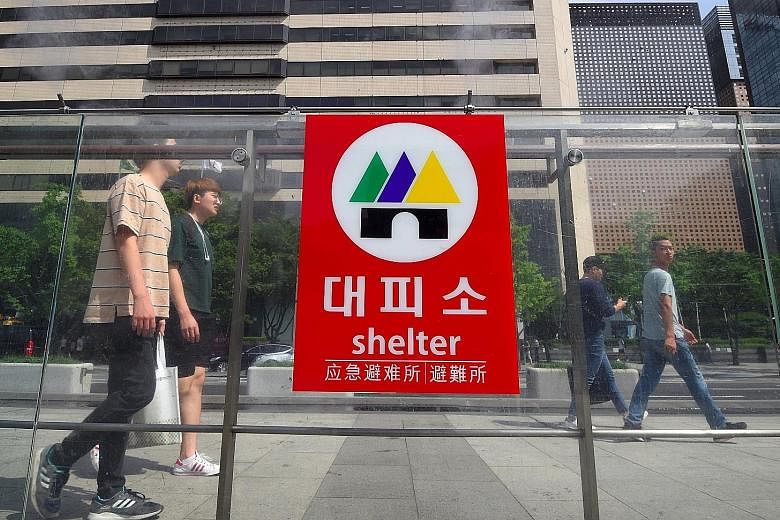 A bomb shelter sign at an exit of a subway station in Seoul this month. A recent poll shows more South Koreans saying humanitarian aid to the North should be cut if it does not give up its nuclear programme.