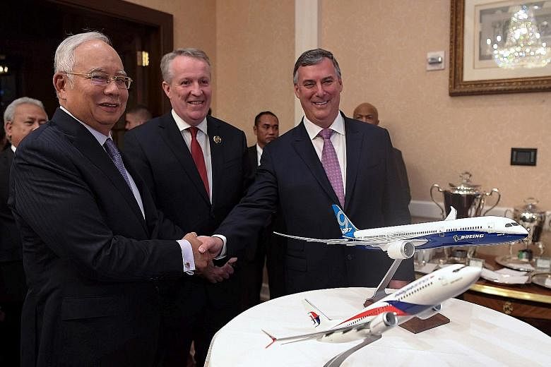 Mr Najib Razak shaking hands with Mr Kevin McAllister, chief executive officer of Boeing Commercial Airplanes, at a memorandum of understanding exchange ceremony between Boeing and Malaysia Airlines in Washington on Wednesday. With them is Malaysia A