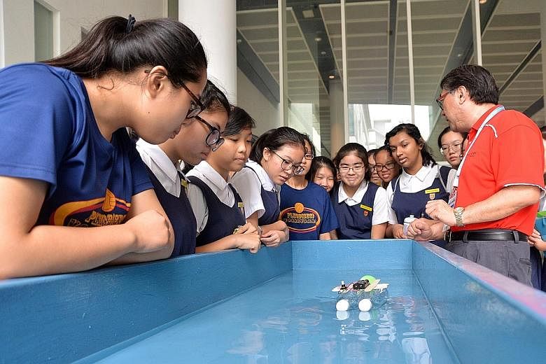 Students from Paya Lebar Methodist Girls' School attending an electrical boat-building workshop conducted by Ngee Ann Polytechnic course manager Zhou Yili.