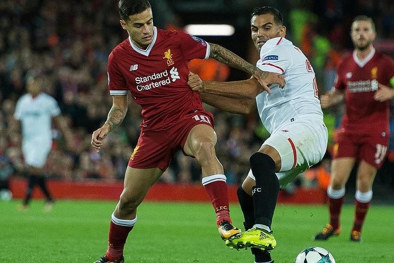 Reds playmaker Philippe Coutinho tussling with Sevilla's Gabriel Mercado during their Champions League Group E tie at Anfield. The Brazilian, who handed in a transfer request, saw his dream move to Barca collapse but will now knuckle down to win back