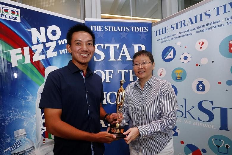 ST sports editor Lee Yulin presenting the ST Star of the Month award to Marc Ong. The 21-year-old golfer sank the winning birdie putt on the third play-off hole that secured the SEA Games men's team gold for Singapore.