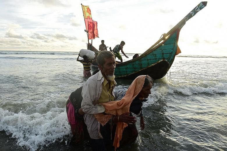 Rohingya refugees disembarking from a Bangladeshi boat on the shores of the Naf river in Teknaf, after crossing from Myanmar on Thursday.