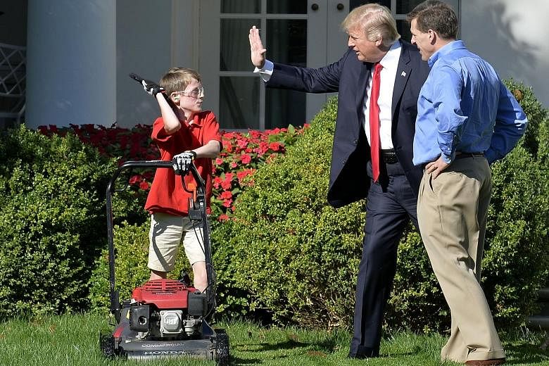 President Donald Trump high-fiving young entrepreneur Frank Giaccio, who had written to the White House offering his lawn-mowing skills.