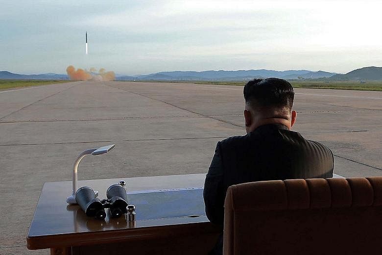 An undated picture released by North Korea's official Korean Central News Agency yesterday showing Mr Kim Jong Un inspecting a launch drill of the Hwasong-12 missile at an undisclosed location.