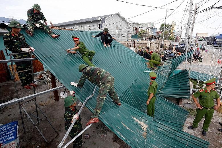 Soldiers repairing a damaged roof in Ha Tinh province. Some 123,000 homes were damaged.