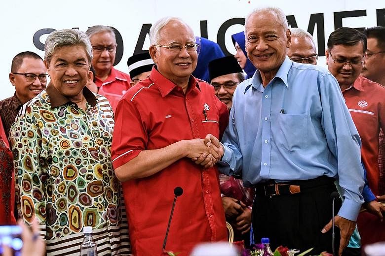 Malaysian Prime Minister Najib Razak, who is also Umno president, shaking hands with former Selangor menteri besar Muhammad Muhammad Taib as he welcomes the latter back to the ruling party.