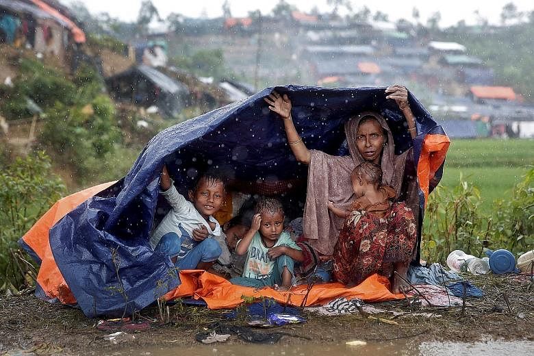Rohingya refugees taking shelter from the rain in a camp in Cox's Bazar, Bangladesh, yesterday. More than 400,000 members of Myanmar's Rohingya Muslim minority have fled the country's western Rakhine state to Bangladesh in an effort to escape a milit