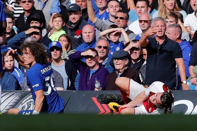 Arsenal's Sead Kolasinac clutches his left shin after a challenge by Chelsea centre-back David Luiz. The Brazilian was sent off in the 87th minute and Arsenal had little time to capitalise on their numerical advantage.