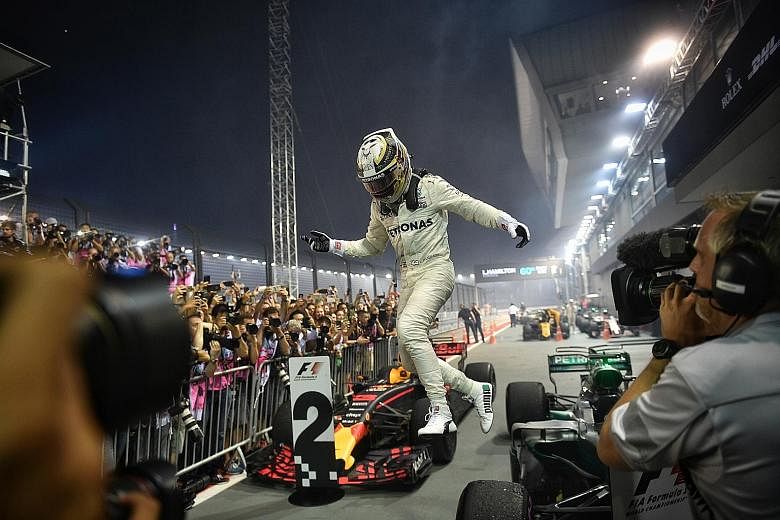 An ecstatic Lewis Hamilton jumping off his Mercedes after winning a third Singapore Grand Prix last night, to take a commanding lead over Ferrari's Sebastian Vettel.