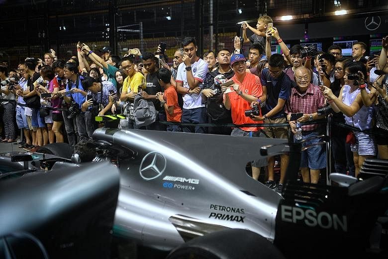 Fans get up close to watch the Mercedes pit crew in action during the Thursday Pit Lane Experience at the Marina Bay Street Circuit on Sept 14. Giving fans an enhanced experience is a pivotal strategy for the sport's new American owners.