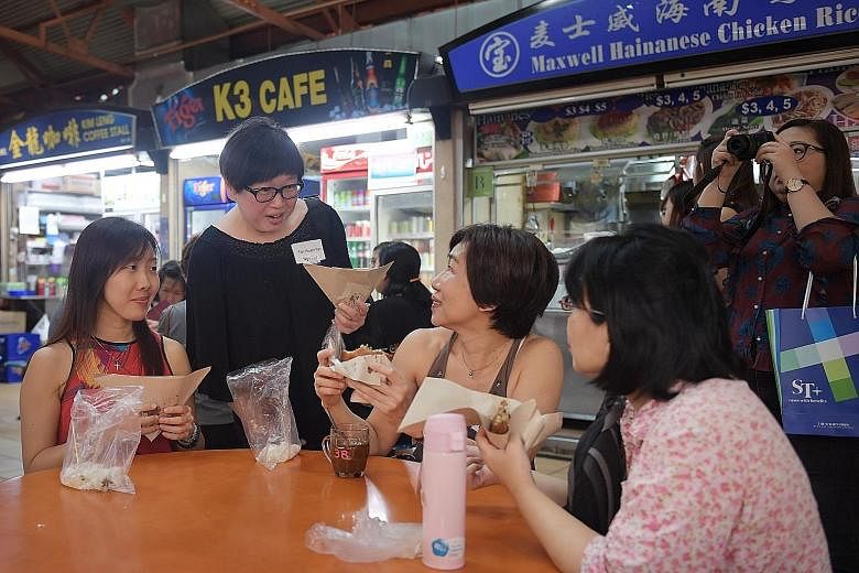 The ST Hawker Masters Hopping Trail, hosted by Straits Times Life editor Tan Hsueh Yun (standing), took readers to five food centres, where they feasted on food such as fried oyster cake.