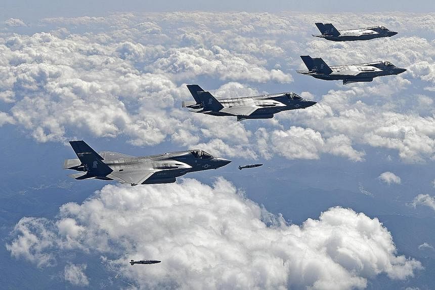 US F-35 jets droppingbombs to hit simulated targets during a drill in South Korea yesterday. According to South Korean Defence Minister Song Young Moo, the joint drills are being held two to three times a month these days.