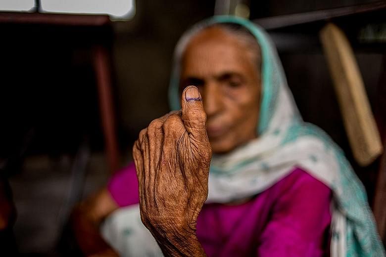 A Nepali woman showing her inked thumb after casting her ballot in the local elections at a polling station in Birgunj Parsa district, south of Kathmandu, yesterday.