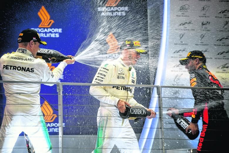 Singapore Grand Prix winner Lewis Hamilton on the podium with second-placed team-mate Valtteri Bottas and Red Bull's Daniel Ricciardo. The Briton leads the world championship by 28 points with six races remaining.