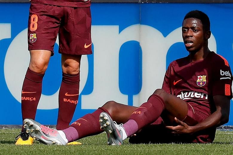 Barcelona's record signing Ousmane Dembele reacts after suffering a hamstring injury during the LaLiga match against Getafe.