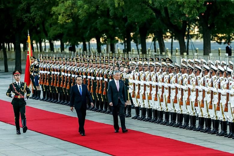 Prime Minister Lee Hsien Loong and Chinese Premier Li Keqiang inspecting the guard of honour at a welcome ceremony in front of the Great Hall of the People before their meeting in Beijing yesterday.