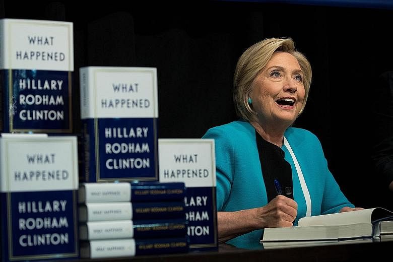 Former US presidential candidate Hillary Clinton signing copies of her new book, What Happened, on Sept 12 in New York City. The book details her campaign and election loss last year.