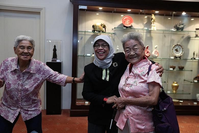Madam Sim Goon Hua (left) and Madam Lim Ah Kheoh posing for a picture with President Halimah Yacob yesterday at the Istana. During lunch of steamed fish, chicken, vegetables and rice, they chatted in Mandarin and Malay with the President about their 