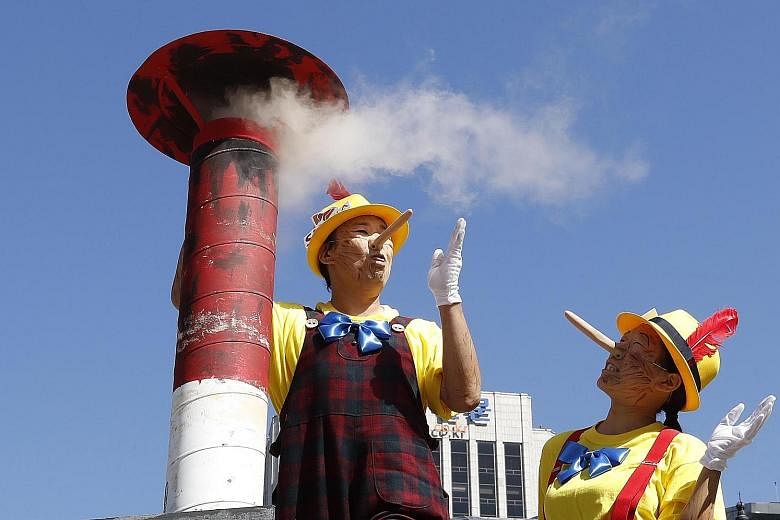 Members of the international environmental group Greenpeace mimicking the fictional character Pinocchio to accuse coal-fired power plant operators of lying that they are eco-friendly, at a protest performance in Seoul, South Korea, yesterday.