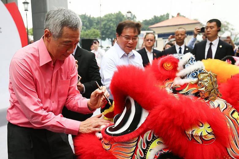 Prime Minister Lee Hsien Loong joining OCBC group chief executive Samuel Tsien (in white) in dotting the lions' eyes at a ceremony to unveil the reconstructed OCBC building in Xiamen.