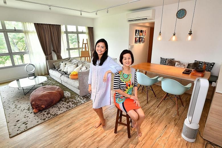Ms Jessica Koh's (left, with her mother Sally Tan) five-room HDB flat has plenty of wooden surfaces and a glass-enclosed kitchen, while pop art representations of cultural icons, such as Katy Perry, Rihanna and Taylor Swift, lend a funky touch.