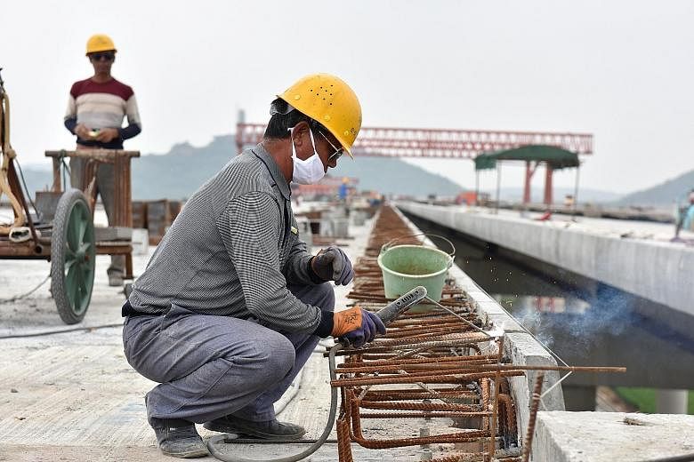 A worker welding reinforcement bars at a construction site in Hefei. While UBS sees S&P's downgrade of China's credit rating as no cause for panic, IG Asia market strategist Pan Jingyi feels that the coming Golden Week break may make the market excep