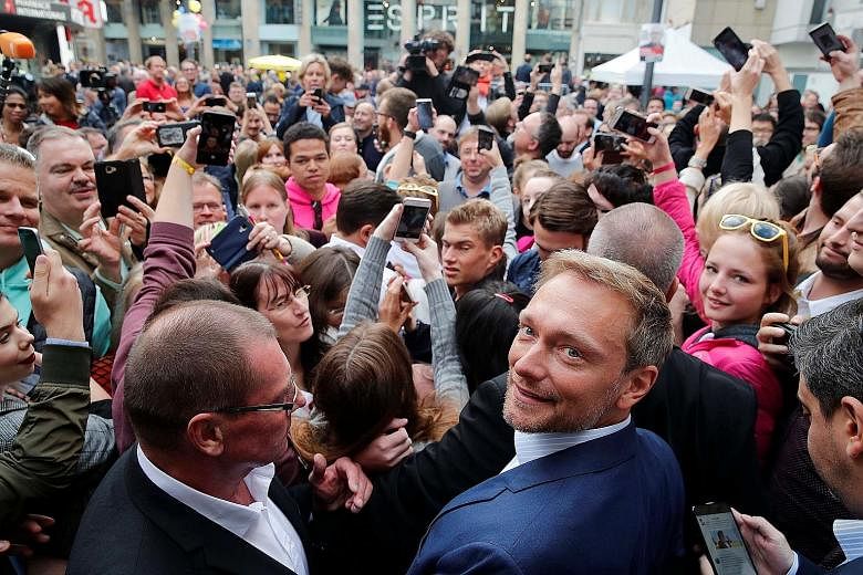 Free Democratic Party (FDP) leader Christian Lindner (in blue suit) with supporters eager to take a picture with him during a campaign rally in Dusseldorf, Germany, last Saturday. With Mr Lindner putting the spotlight back on the FDP, the party could