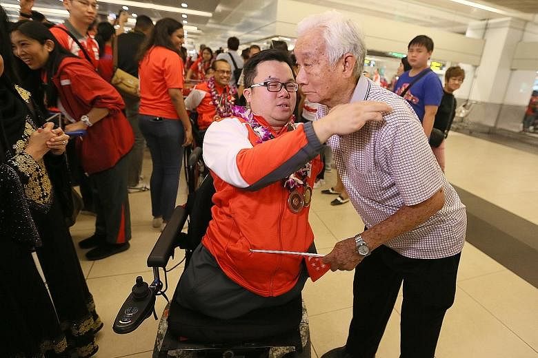 Jason Chee greeted by his father Chee Kwok Chor at Changi Airport as Singapore's Asean Para Games contingent returned from their record away medal haul at Kuala Lumpur. The contingent were treated to a rousing welcome at the arrival hall by a party t