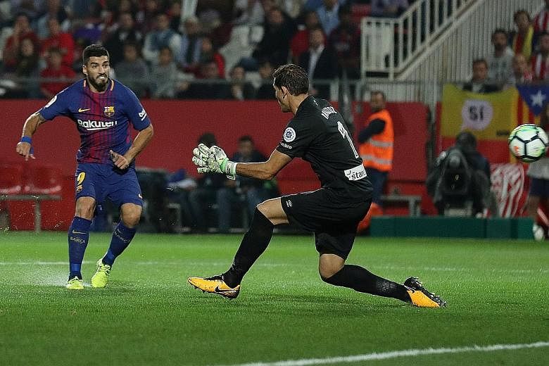 Barcelona striker Luis Suarez firing past Girona goalkeeper Gorka Iraizoz for his side's third and final goal. The Uruguayan international has plundered 87 goals in his 100 Spanish LaLiga games for the Catalan giants.