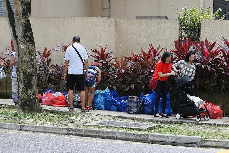 Bags of items at what appeared to be a makeshift stall outside Richmond Park condo near Lucky Plaza yesterday. From as early as July last year, mall retailers have noticed itinerant sellers hawking items out of bags.