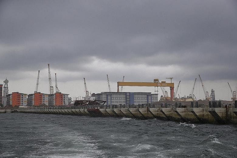 Above: Caissons are used to build the wharf structure. The 28m-high concrete watertight structures are each about the height of a 10-storey Housing Board block. Left: Two completed caissons, one of which is in the floating dock (far left), awaiting t