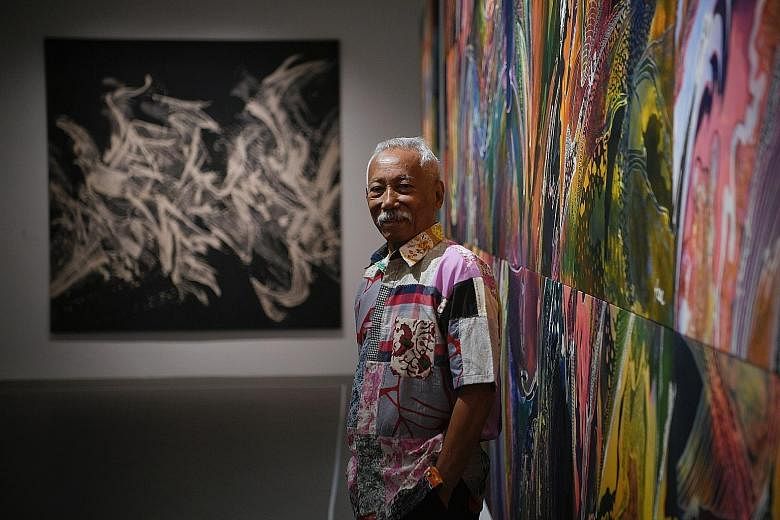 Batik artist Sarkasi Said with his artworks View Of Life (right) and Light (background) at his solo exhibition at the National University of Singapore Museum.