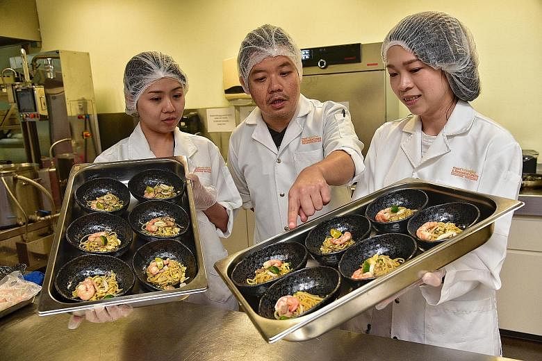 Members of the Food Innovation & Resource Centre team (from left) Wenie Chin, Martyn Wong Kang Loong and Ho Seeh Ming with the new noodle prototypes. The research centre has developed wholegrain yellow noodles made with beta-glucan, a soluble fibre, 