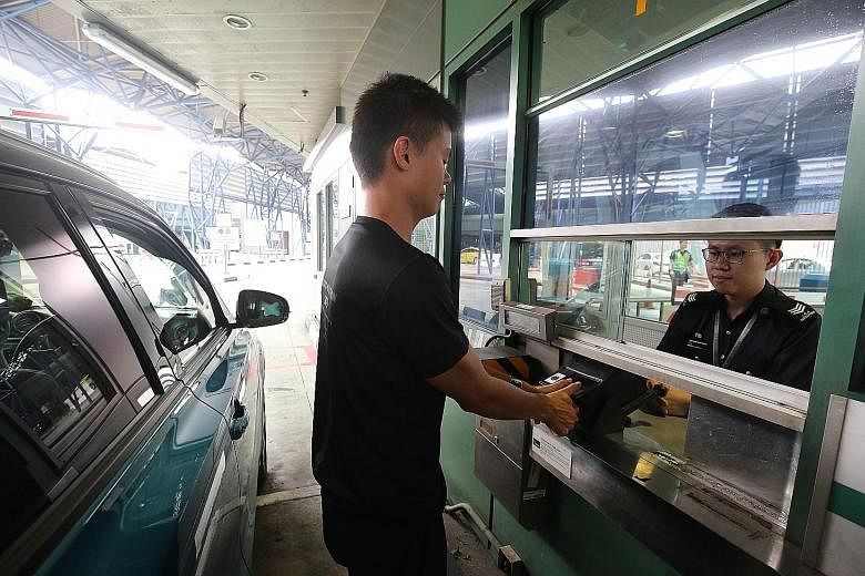 A traveller having his thumbprints scanned at the Woodlands checkpoint. ICA officers will be present to help people use the BioScreen machines.