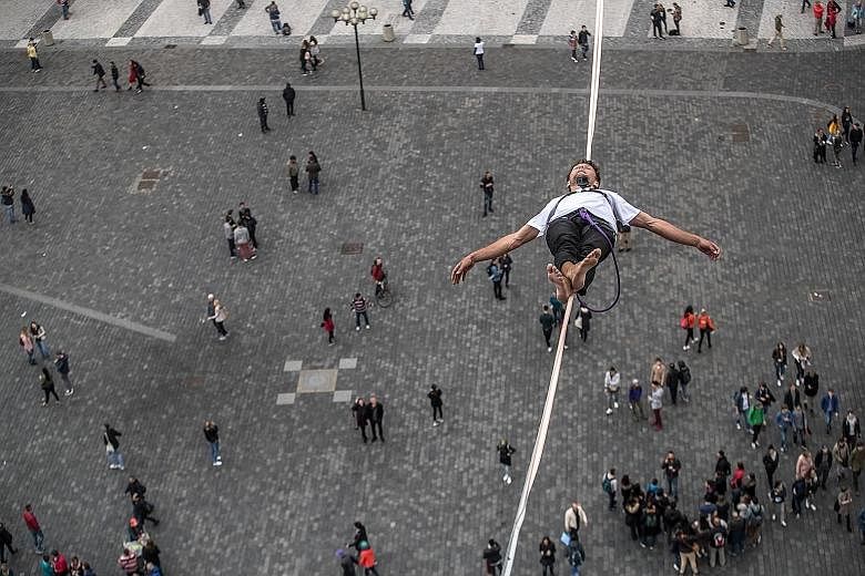 A participant balancing precariously on a slackline over the Old Town Square in Prague, the capital of the Czech Republic, yesterday. The daredevil feat was part of a campaign in support of people living with diabetes.