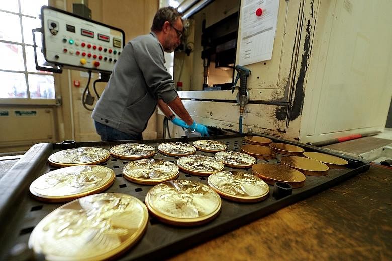 An employee mans a stamping machine at the factory of the Monnaie de Paris (Paris Mint) last Thursday, ahead of its reopening in Paris, France. After more than 1,000 years of service, the mint opened to the public a vast exhibition of treasures, coll