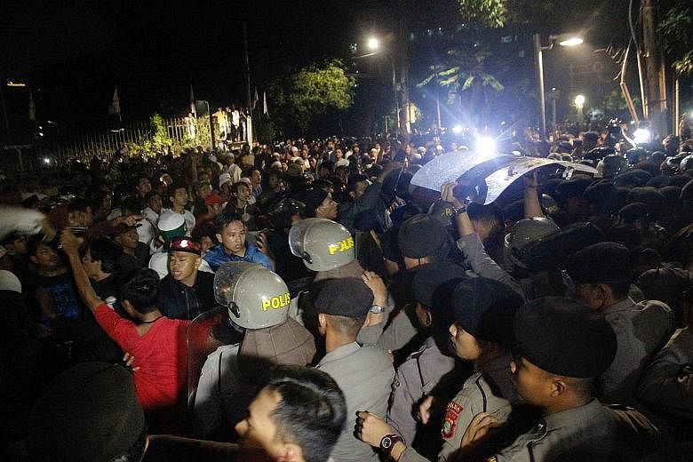 Anti-communist protesters clashing with police outside the Indonesian Legal Aid Foundation building in Jakarta on Sept 18. The mob had gathered at the location earlier on Sept 17 to protest against a suspected gathering of the long-defunct Communist 