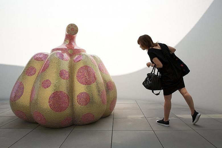 A visitor looking at the sculpture titled Starry Pumpkin by Yayoi Kusama, known for her polka dots and pumpkins, during a media preview of the museum in Tokyo on Tuesday.