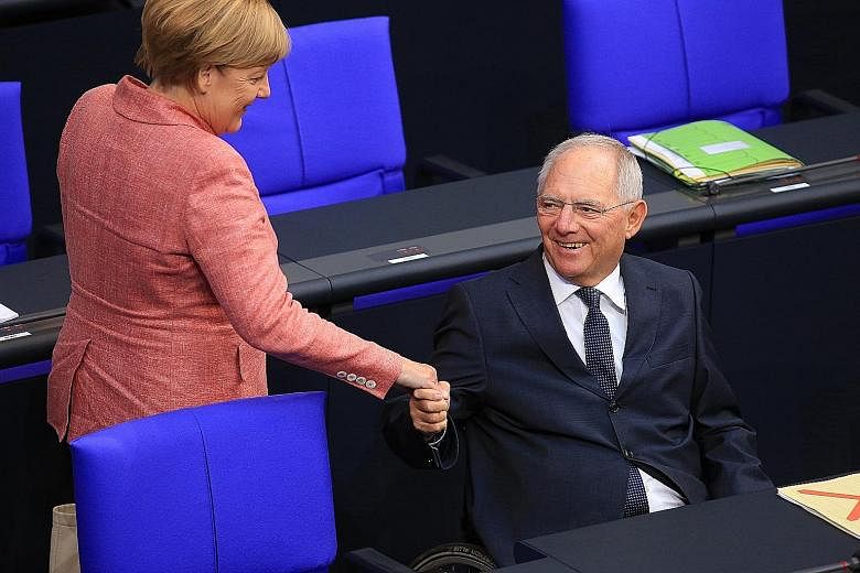Mr Wolfgang Schaeuble with Chancellor Angela Merkel in the Bundestag on Sept 6. His 45 years in the Bundestag make him Germany's longest-serving lawmaker.