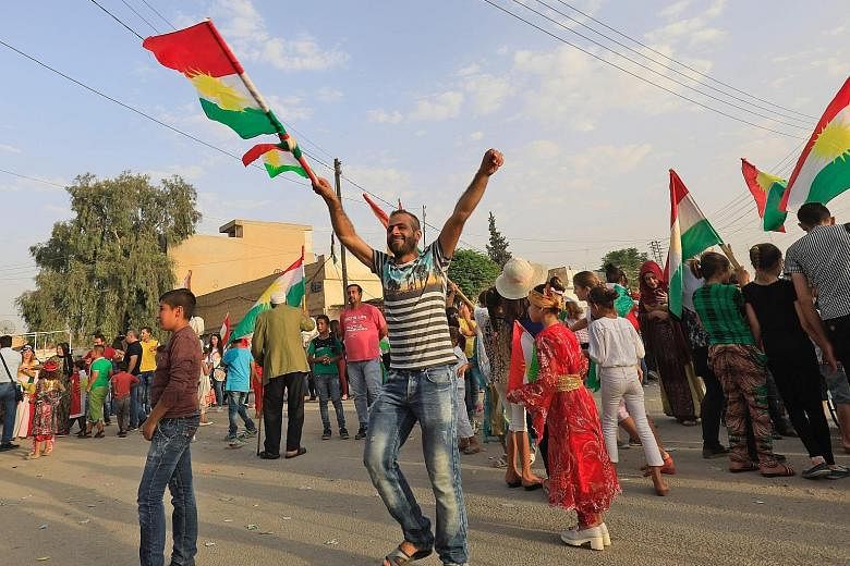 Syrian Kurds dancing with the Kurdish flag as they celebrate the outcome of the independence referendum in the north-eastern Syrian city of Qamishli on Monday.