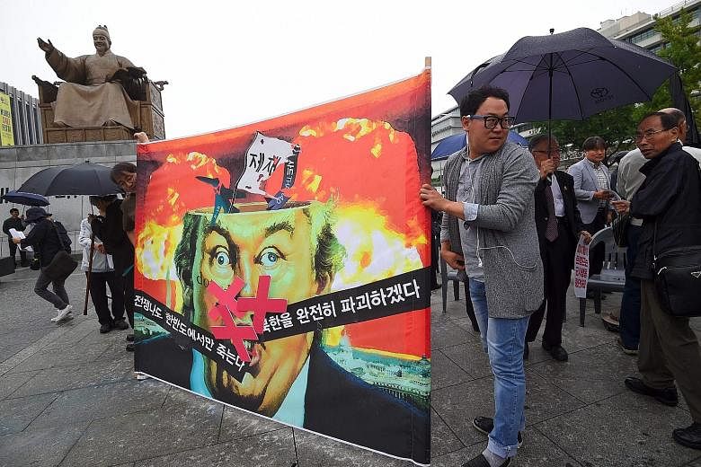 Anti-war activists displaying a banner showing a caricature of US President Donald Trump during an anti-Trump rally near the US Embassy in Seoul yesterday. The Korean script on the banner reads "If war breaks out, only those on the Korean peninsula w