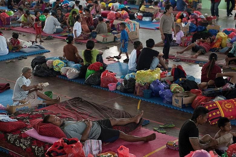 Balinese taking refuge at a temporary evacuation centre yesterday as Mount Agung continued to send out signals of imminent eruption. More than 120,000 people have fled to safety, and officials have warned people to stay at least 9km away from the vol