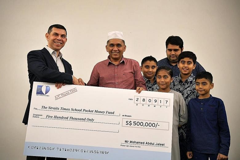 Mr Warren Fernandez, chairman of The Straits Times School Pocket Money Fund, receiving a donation of $500,000 from Mini Environment Service Group founder and CEO Mohamed Abdul Jaleel yesterday. With them were Mr Jaleel's son Mohamed Jinna and grandch