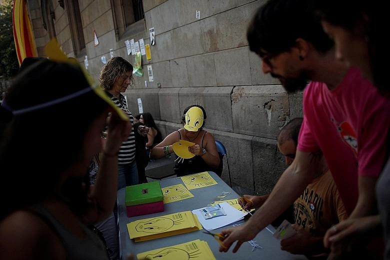 Protesters handing out masks before a demonstration over the referendum outside the University of Barcelona on Wednesday.