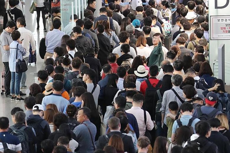 South Korean President Moon Jae In greeting other visitors to Odaesan while visiting the mountain during his summer vacation in July. Above: Ms Gwen Chang (fourth from right), seen here beside her husband, went surfing in Bali over the Chuseok holida