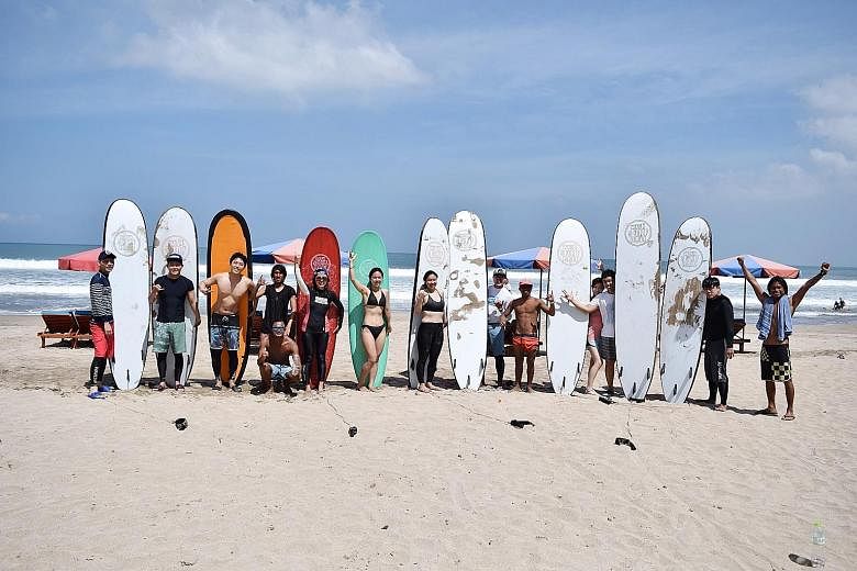 South Korean President Moon Jae In greeting other visitors to Odaesan while visiting the mountain during his summer vacation in July. Above: Ms Gwen Chang (fourth from right), seen here beside her husband, went surfing in Bali over the Chuseok holida
